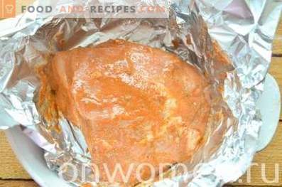 Jamón de cerdo cocido al horno en papel de aluminio en el horno